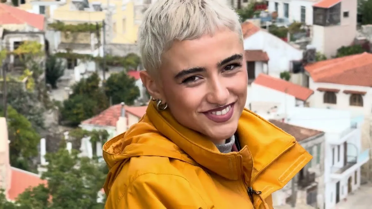 Still from the ProCamera film shot on Crete: a woman in an ochre jacket above the rooftops
